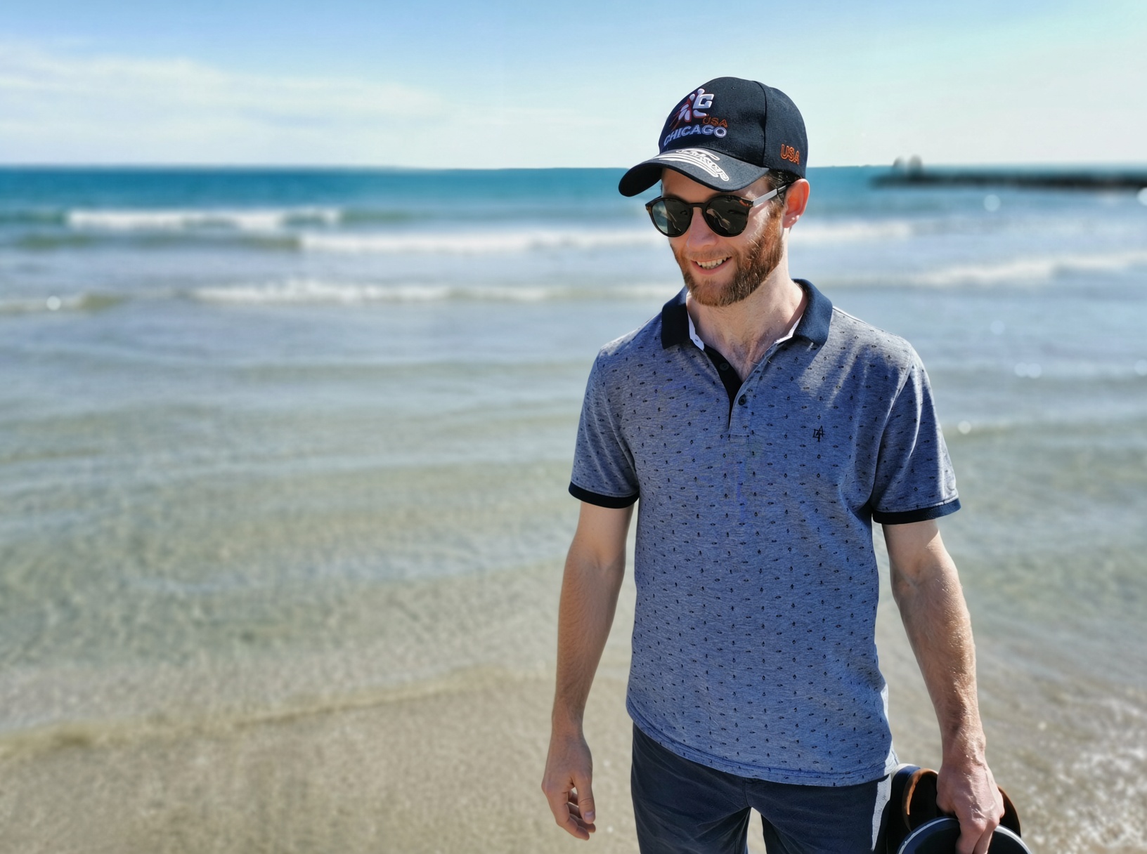 Shaun Williams smiling on a beach by the sea